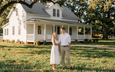 Farm couple in front of white farmhouse - online dating success stories